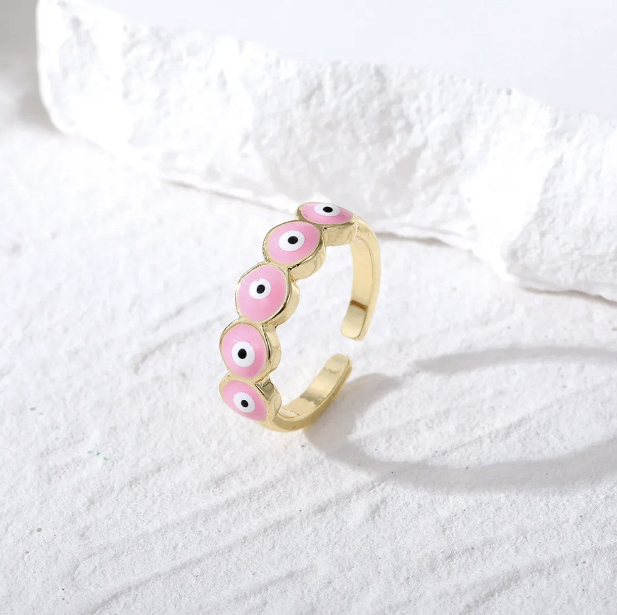 Zara Ring featuring a chunky jewelry design with vibrant pink enamel evil eyes on gold alloy.